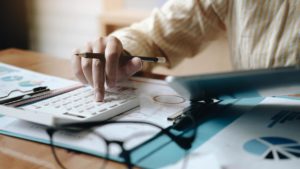 woman accounting using calculating and work with laptop computer on desk office finance concept free photo