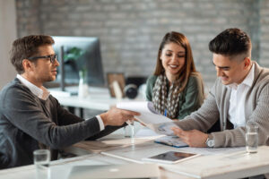 pareja feliz firmando contrato reunion su agente inmobiliario oficina