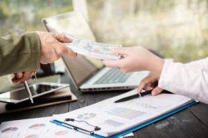 empresario dando dinero su socio al hacer contrato