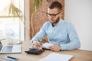adulto serio barbudo caucasico gerente finanzas gafas camisa azul sentado comoda oficina ligera