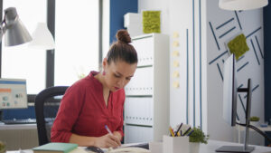 company employee taking notes charts documents working financial presentation business growth office worker planning sales research with e commerce diagram graphs
