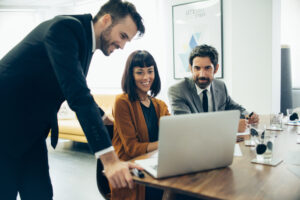 smiling businesspeople working with laptop